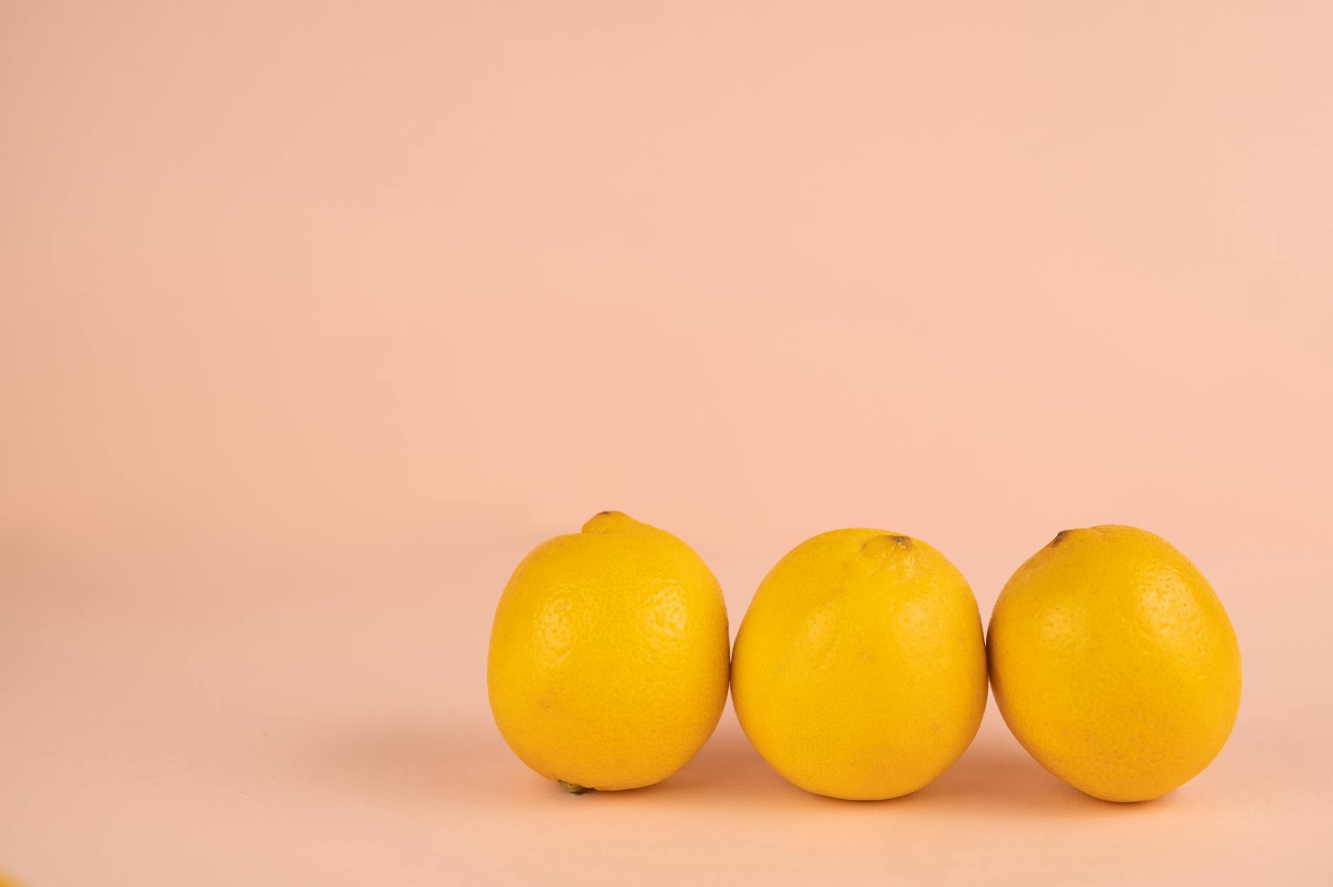 Hand holding an orange vibrator against a minimalistic purple backdrop, showcasing modern sensuality and self-care